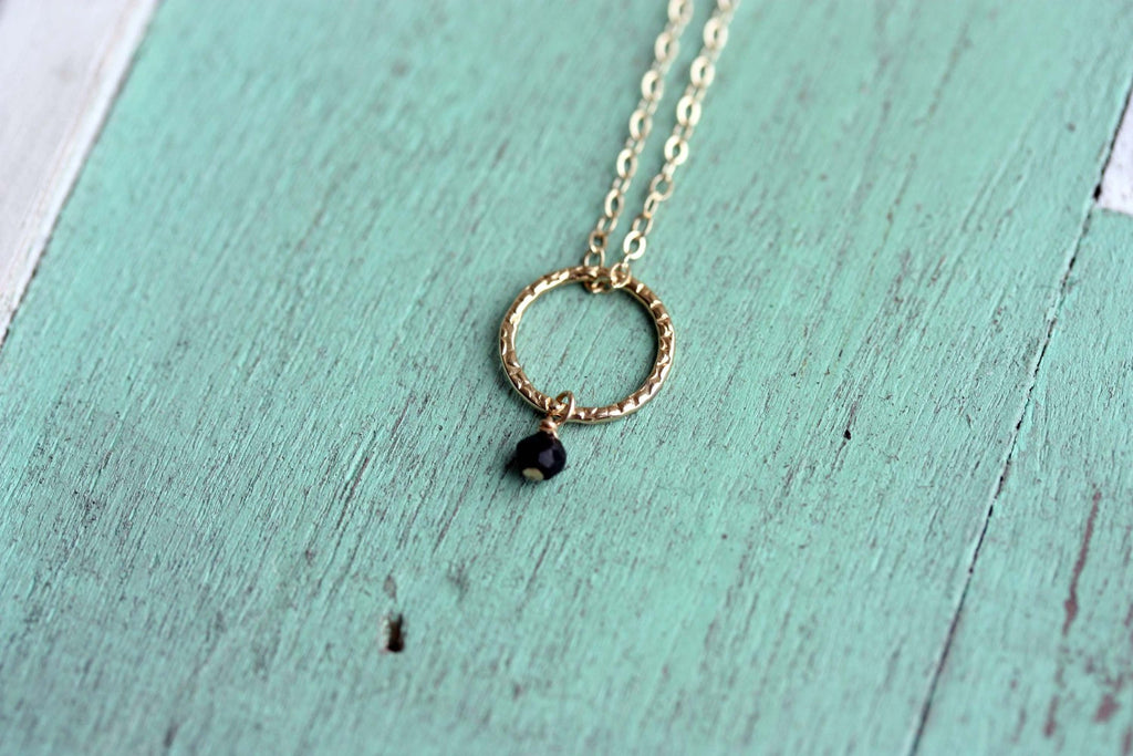 Gold circle and tiny stone necklace from Diament Jewelry, a gift shop in Washington, DC.