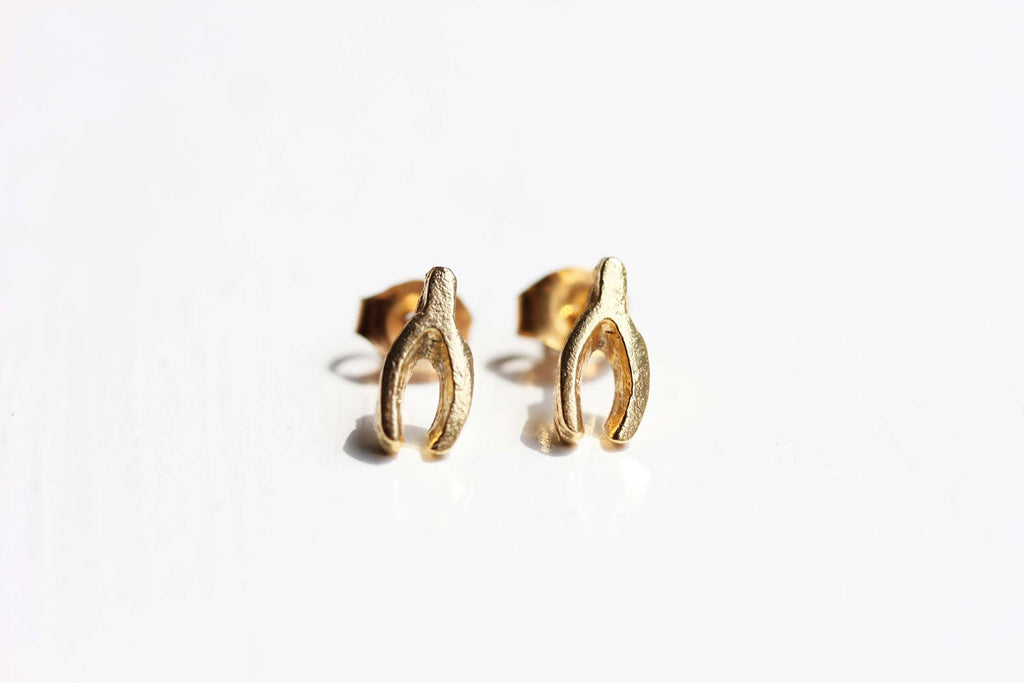 Tiny gold wishbone studs from Diament Jewelry, a gift shop in Washington, DC.