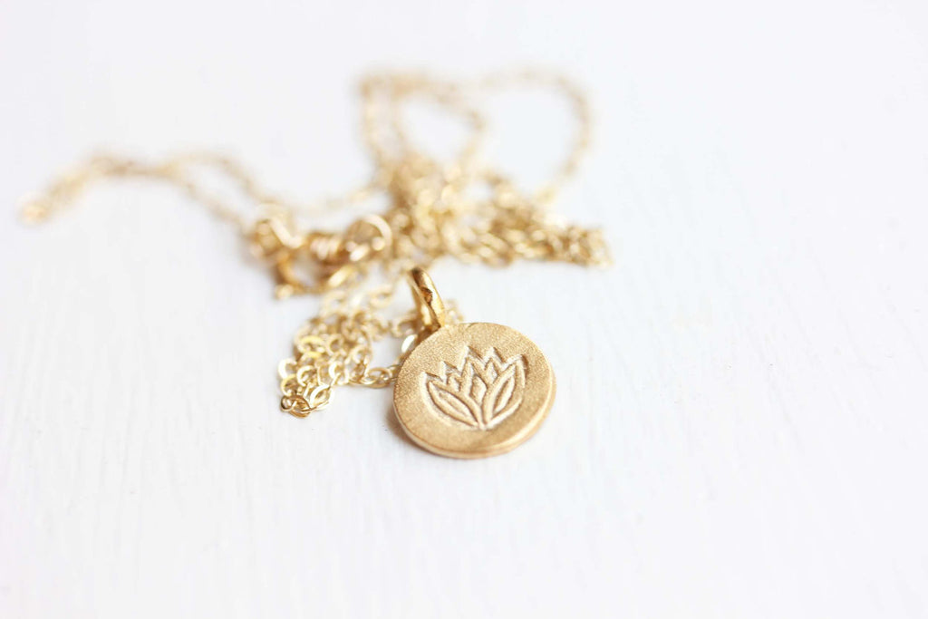 Tiny lotus gold charm necklace from Diament Jewelry, a gift shop in Washington, DC.