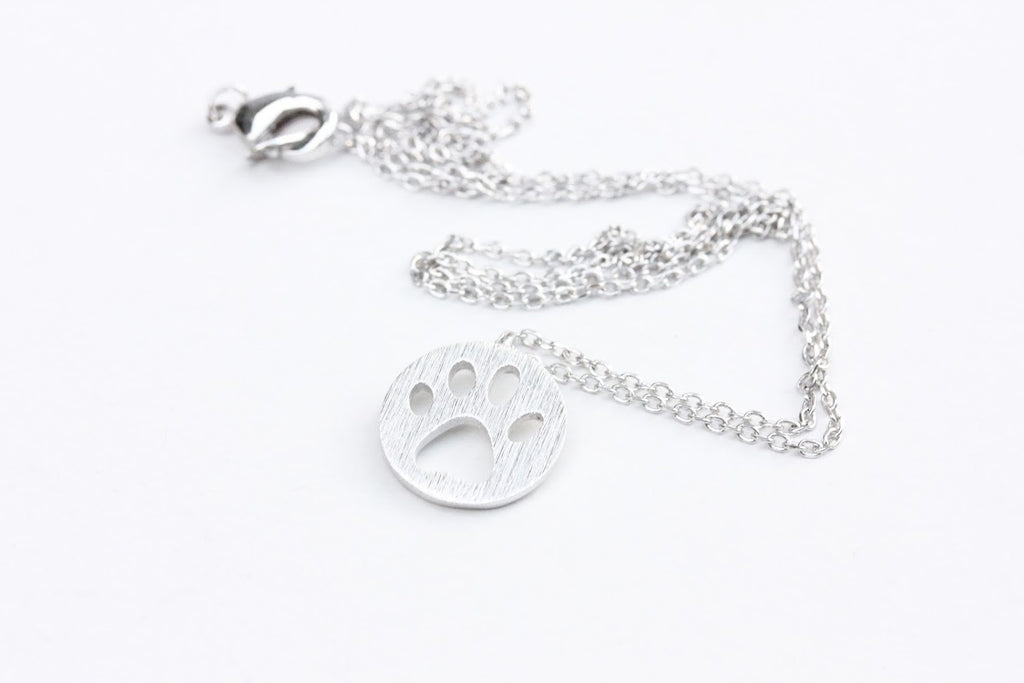 Silver paw print charm necklace from Diament Jewelry, a gift shop in Washington, DC.