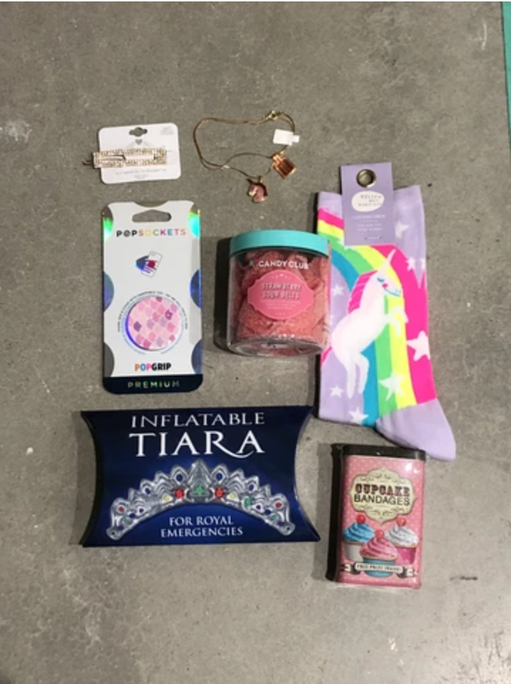 Unicorn kids themed care package with socks, cupcake bandages, inflatable tiara, unicorn necklace, candy, pop socket, and sparkly hair clip from Diament Jewelry, a gift shop in Washington, DC.