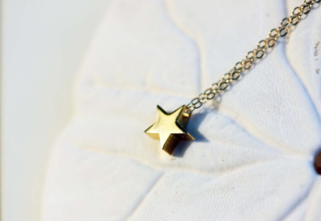Gold star charm necklace from Diament Jewelry, a gift shop in Washington, DC.