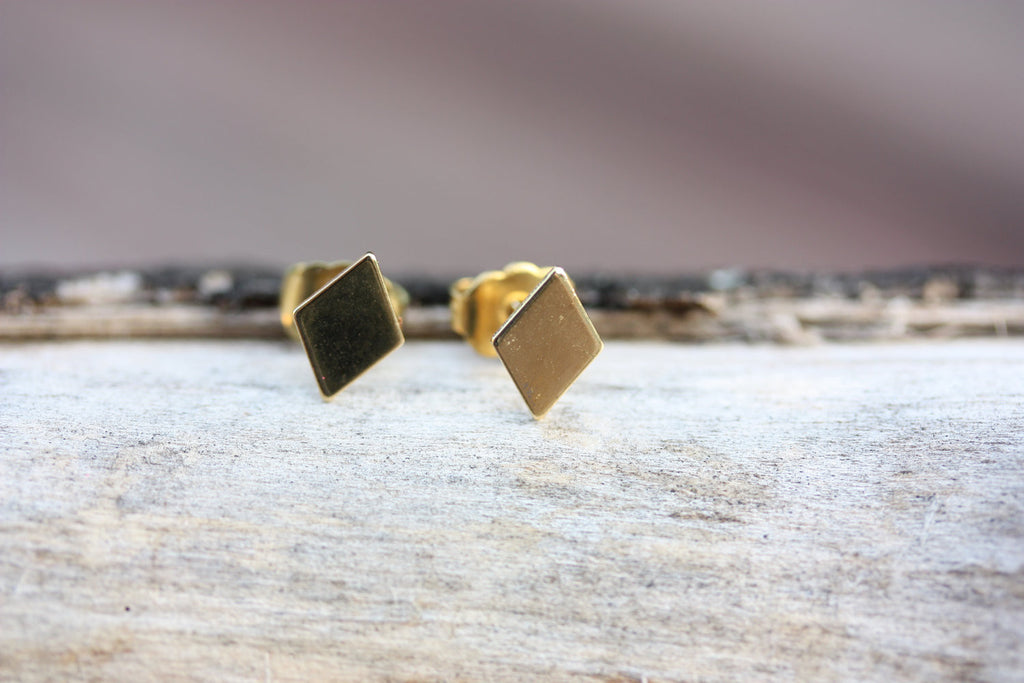Tiny gold diamond shaped studs from Diament Jewelry, a gift shop in Washington, DC.