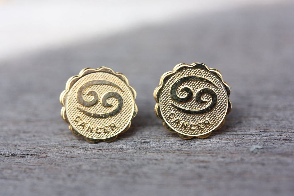 Gold Cancer astrology studs from Diament Jewelry, a gift shop in Washington, DC.