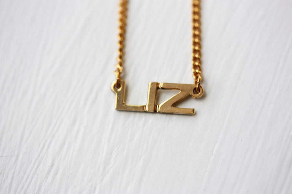 Vintage Liz gold name necklace from Diament Jewelry, a gift shop in Washington, DC.