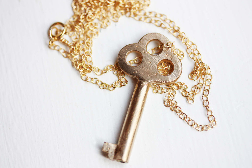Brushed gold key necklace from Diament Jewelry, a gift shop in Washington, DC.