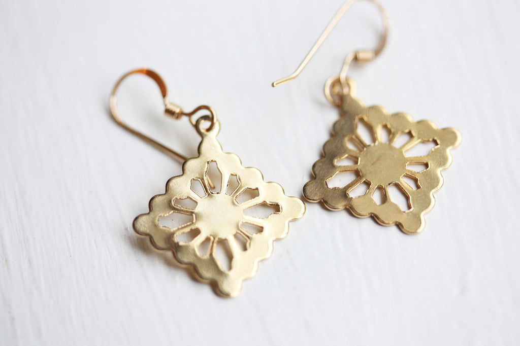 Gold dolly dangle earrings from Diament Jewelry, a gift shop in Washington, DC.