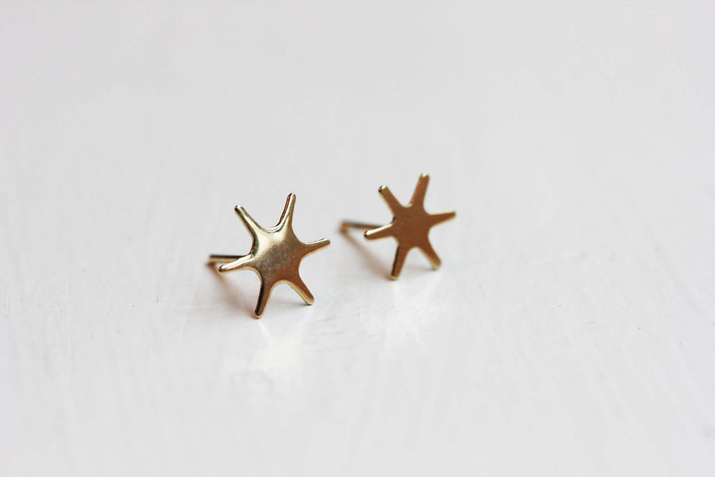 Gold starburst studs from Diament Jewelry, a gift shop in Washington, DC.