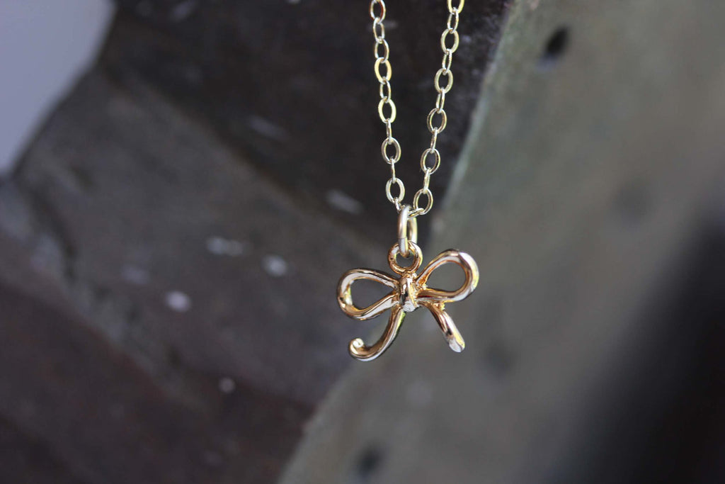 Tiny gold bow necklace from Diament Jewelry, a gift shop in Washington, DC.