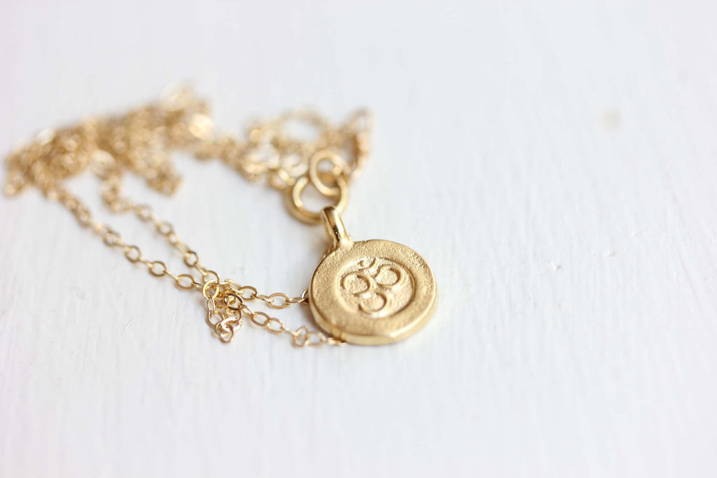Om symbol gold charm necklace from Diament Jewelry, a gift shop in Washington, DC.