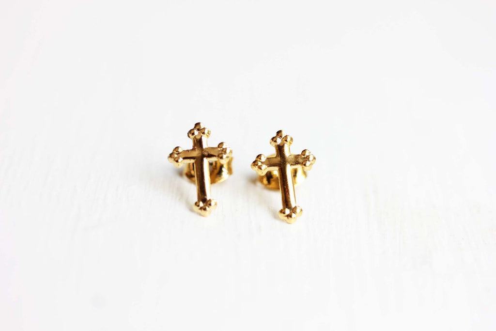 Tiny gold cross studs from Diament Jewelry, a gift shop in Washington, DC.