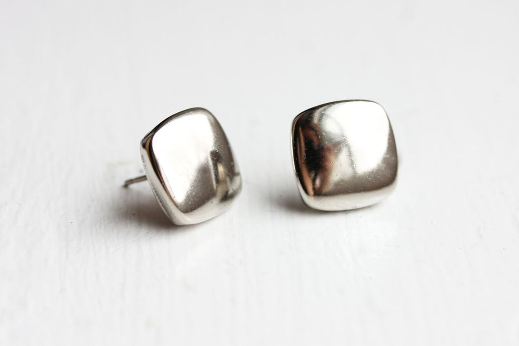 Square puffy silver studs from Diament Jewelry, a gift shop in Washington, DC.